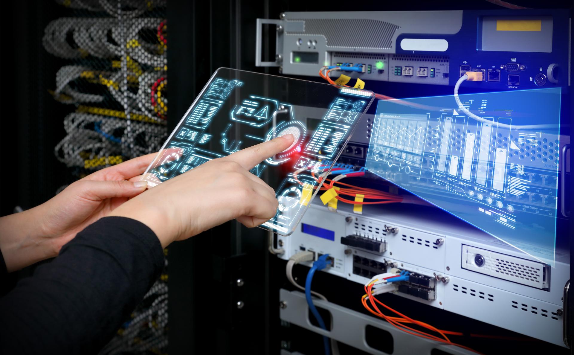 Woman holding AR device panel and analyzing system in server room.